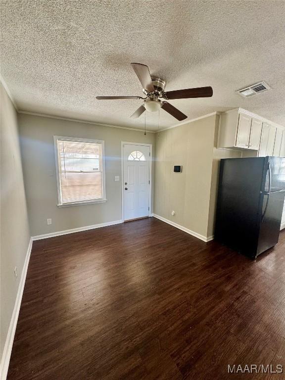 entrance foyer featuring ornamental molding, dark hardwood / wood-style floors, a textured ceiling, and ceiling fan