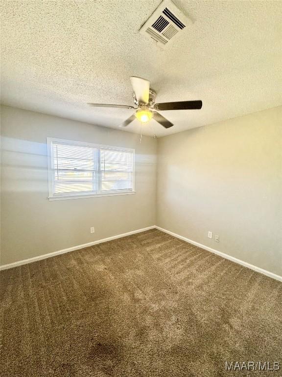 carpeted empty room with ceiling fan and a textured ceiling