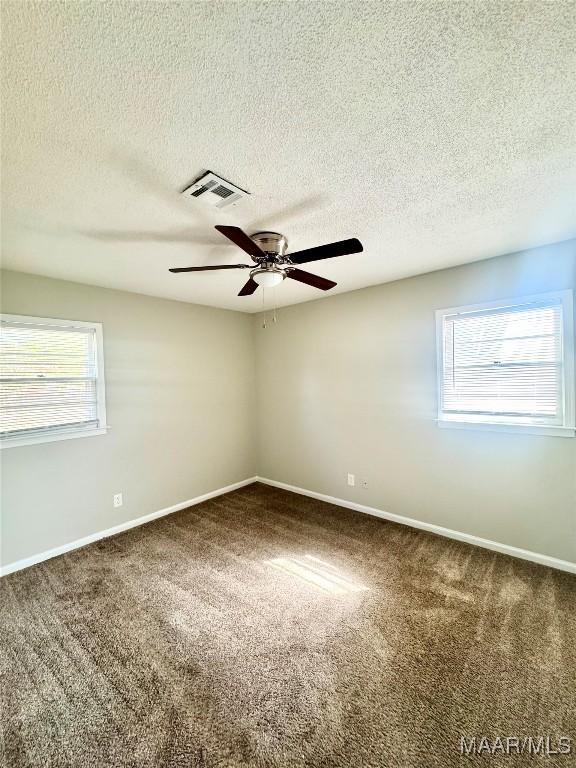 unfurnished room featuring carpet floors, a textured ceiling, and ceiling fan