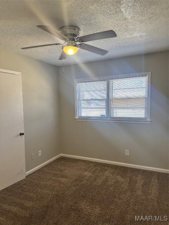 unfurnished room with ceiling fan, carpet floors, and a textured ceiling