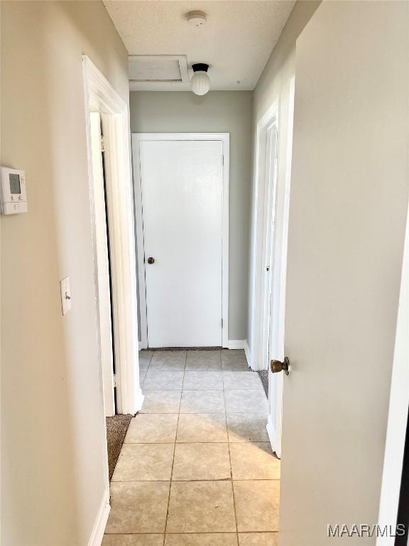 hall with light tile patterned floors