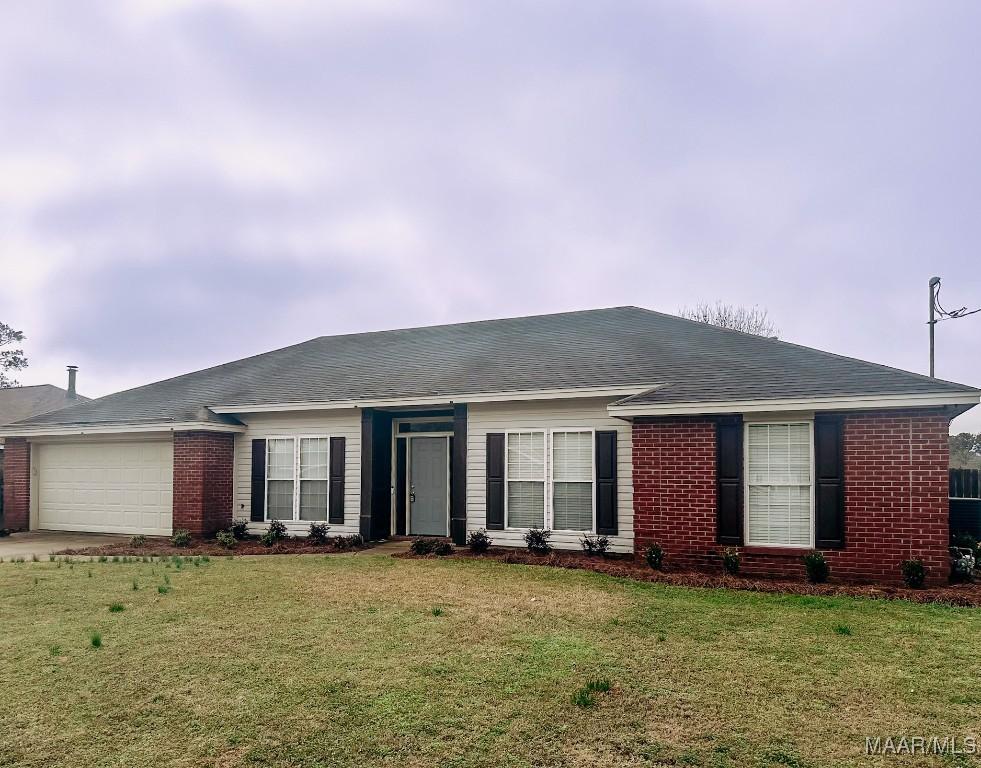 single story home featuring a garage and a front lawn