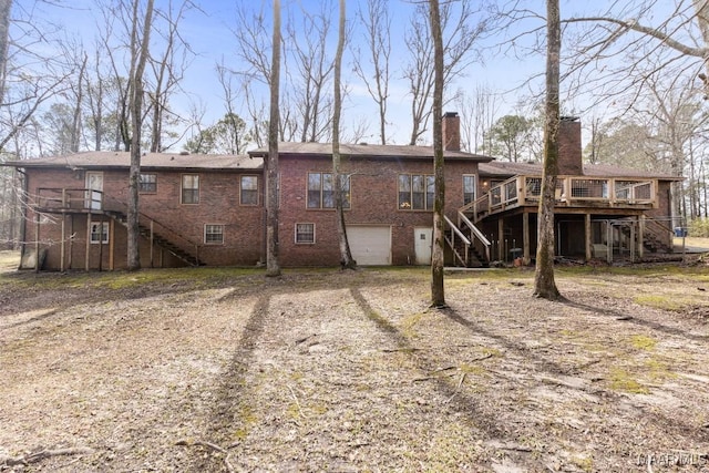 rear view of property with a wooden deck and a garage