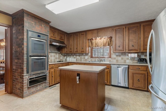 kitchen with stainless steel appliances, a center island, sink, and decorative backsplash