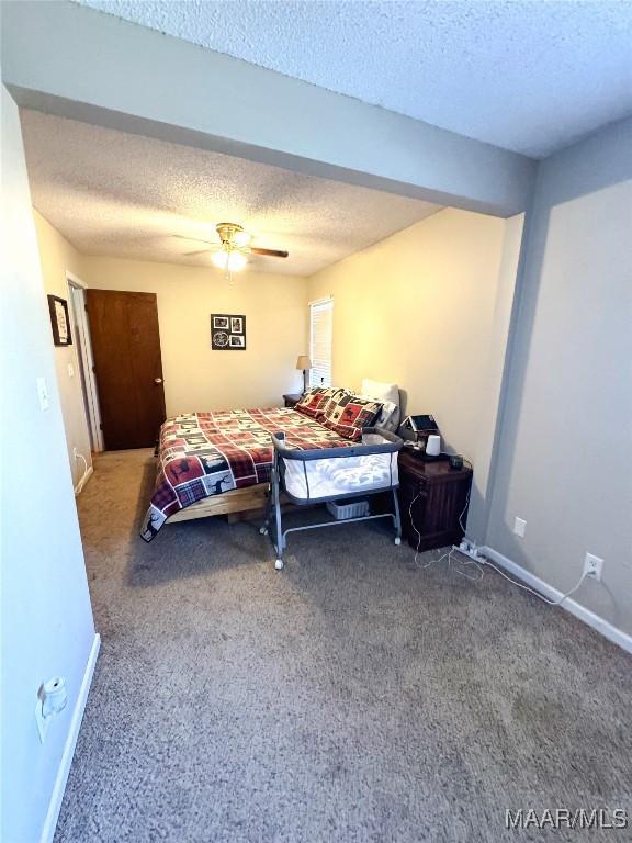 bedroom with ceiling fan, a textured ceiling, and carpet