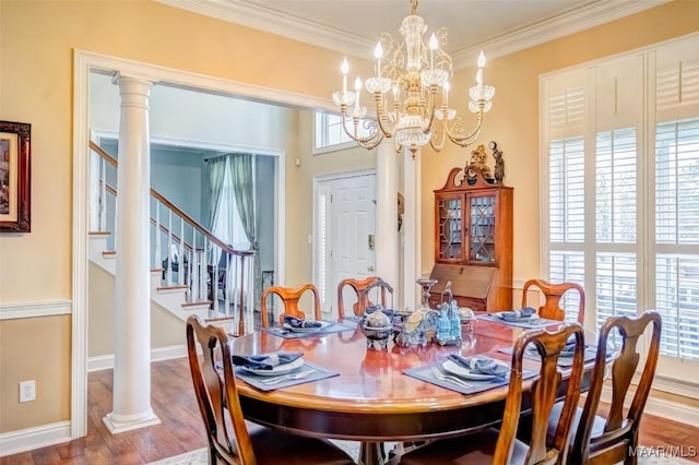 dining space featuring ornate columns, crown molding, and hardwood / wood-style floors