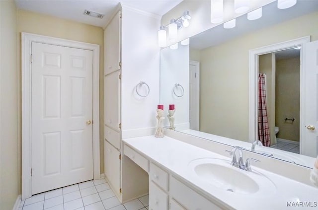 bathroom featuring tile patterned flooring, vanity, and toilet