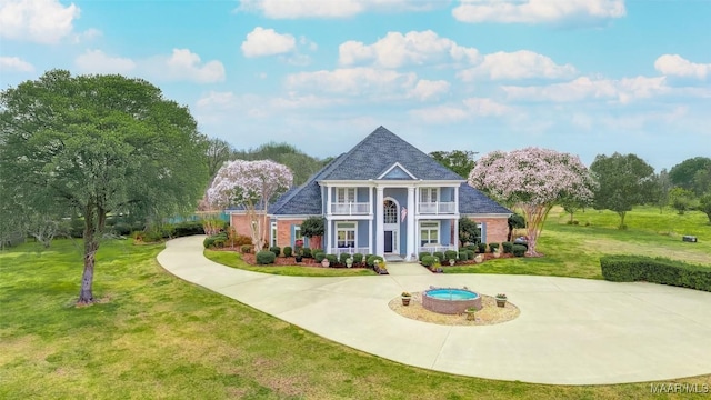 view of front of house with a front yard and a balcony