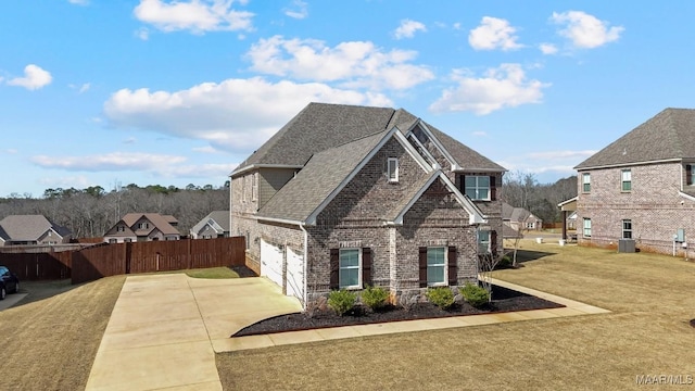 view of front of house with a garage, central AC unit, and a front lawn