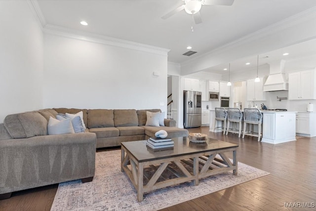 living room featuring dark hardwood / wood-style flooring, crown molding, and ceiling fan