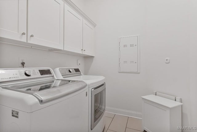 laundry area featuring washer and clothes dryer, cabinets, and light tile patterned flooring