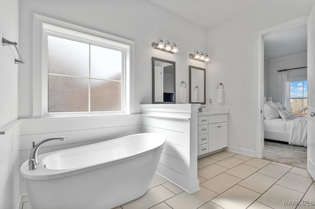 bathroom with tile patterned flooring, a bathing tub, and vanity