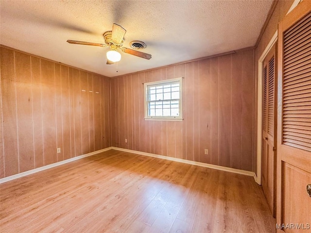 unfurnished room featuring ceiling fan, hardwood / wood-style floors, and a textured ceiling