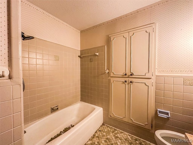 bathroom with tiled shower / bath, tile walls, tile patterned flooring, toilet, and a textured ceiling