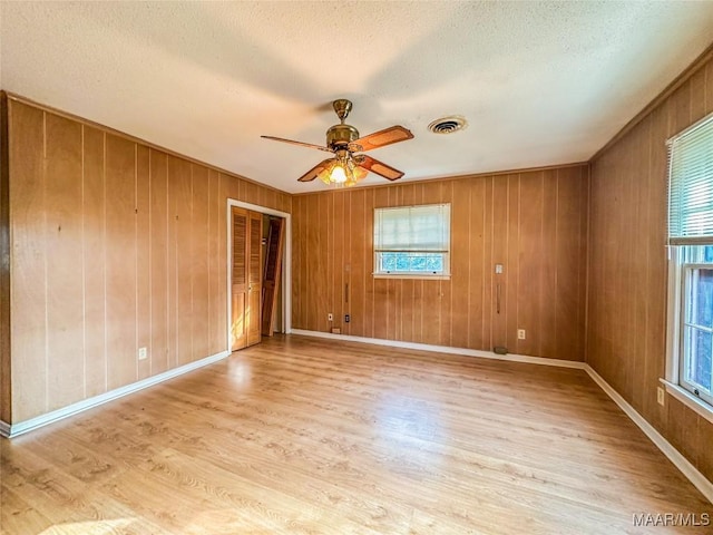 unfurnished room with plenty of natural light, light hardwood / wood-style floors, and ceiling fan