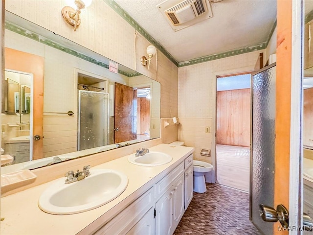 bathroom with tile walls, vanity, and walk in shower