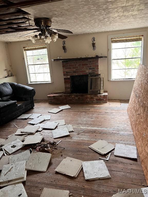 3191 County Road 1124th Rd, Troy, AL 36079 - unfurnished living room featuring ceiling fan, a brick fireplace, and light hardwood / wood-style floors