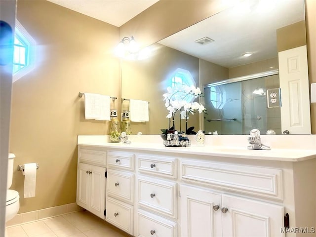 bathroom featuring an enclosed shower, vanity, tile patterned flooring, and toilet