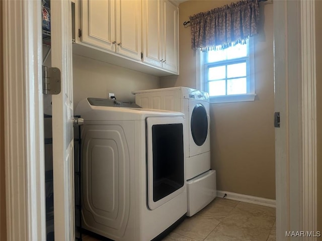 washroom featuring cabinets, washer and clothes dryer, and light tile patterned floors