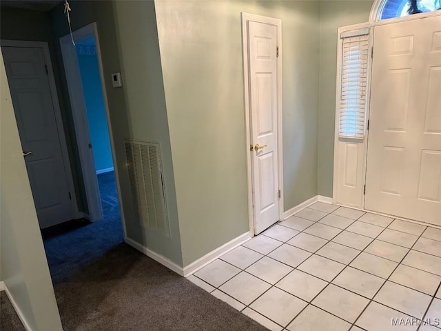 entrance foyer with light tile patterned flooring, baseboards, visible vents, and light colored carpet