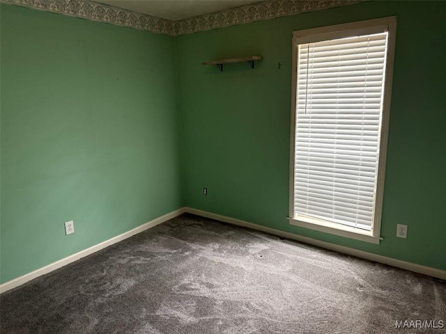 carpeted empty room with a healthy amount of sunlight and baseboards