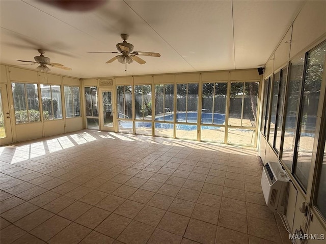 unfurnished sunroom featuring a wall unit AC and ceiling fan