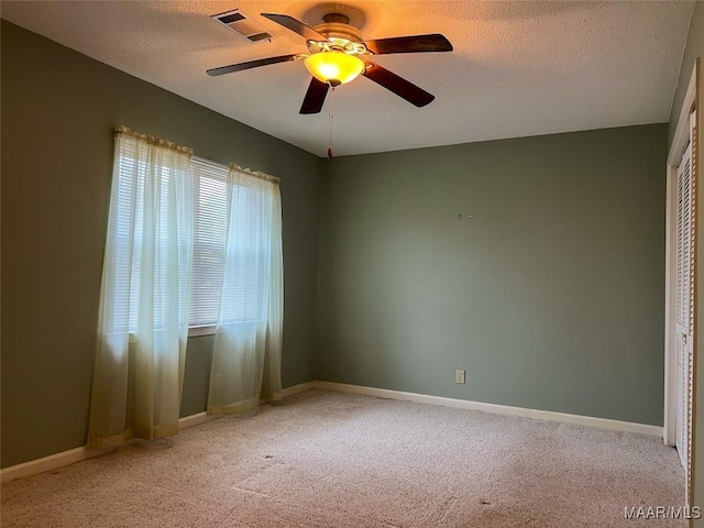 carpeted empty room featuring ceiling fan and a textured ceiling