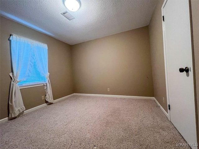 unfurnished room with carpet flooring and a textured ceiling