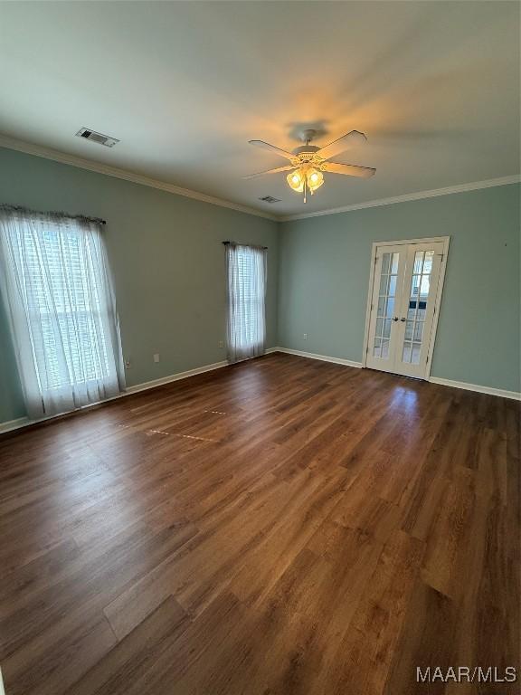 spare room featuring crown molding, dark hardwood / wood-style floors, a wealth of natural light, and french doors