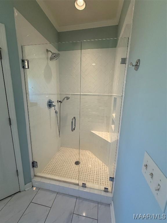 bathroom with crown molding and an enclosed shower