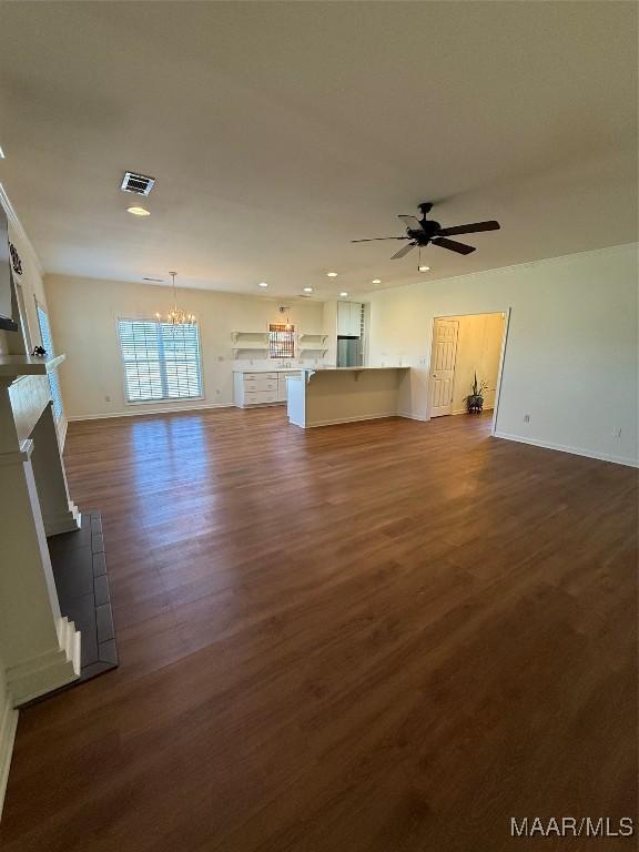 unfurnished living room with dark wood-type flooring and ceiling fan with notable chandelier