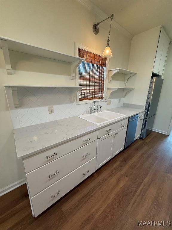 kitchen with sink, hanging light fixtures, appliances with stainless steel finishes, dark hardwood / wood-style flooring, and white cabinets