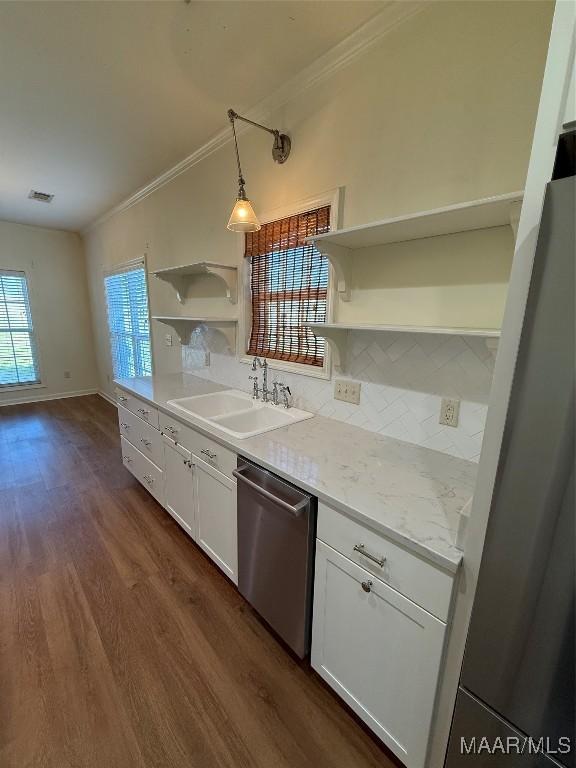 kitchen featuring hanging light fixtures, stainless steel appliances, sink, and white cabinets