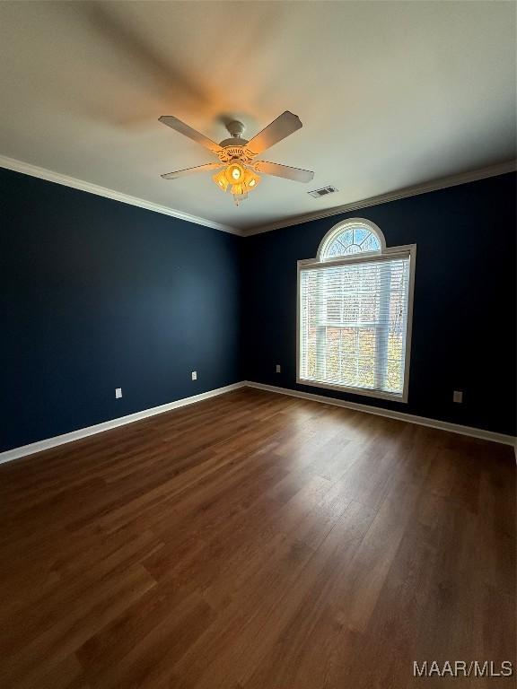 empty room with hardwood / wood-style flooring, crown molding, and ceiling fan