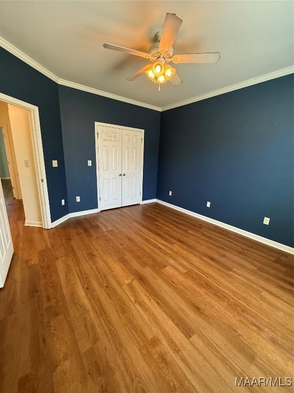 unfurnished bedroom featuring ornamental molding, ceiling fan, and light hardwood / wood-style flooring