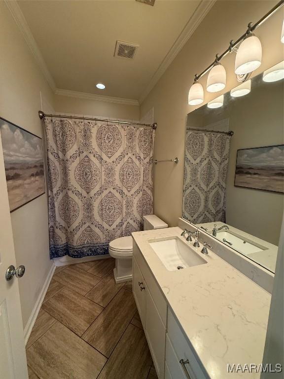 bathroom featuring vanity, crown molding, and toilet