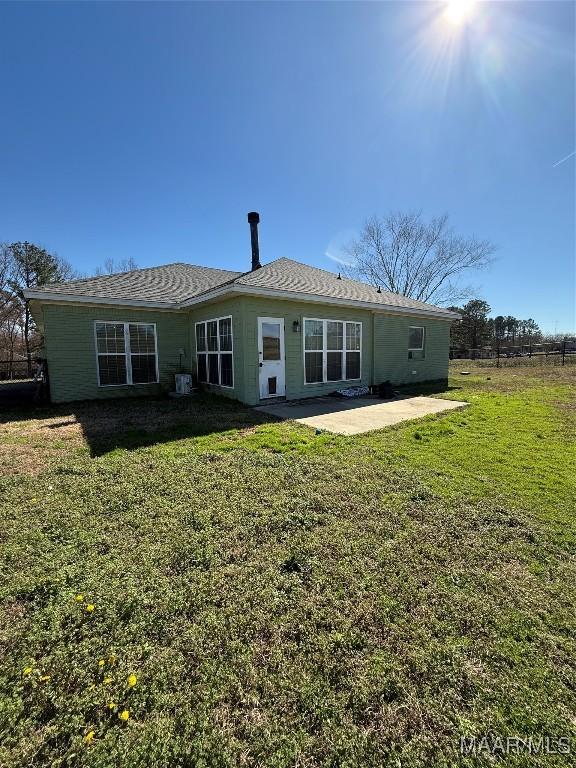 rear view of house featuring a patio and a lawn