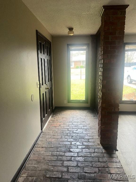 doorway to outside with plenty of natural light and a textured ceiling