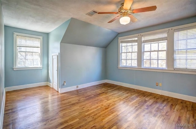 additional living space with ceiling fan, lofted ceiling, plenty of natural light, and light hardwood / wood-style floors