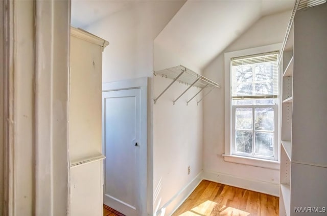 walk in closet with lofted ceiling and light wood-type flooring