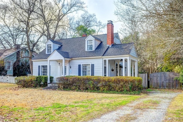 cape cod home featuring a front lawn