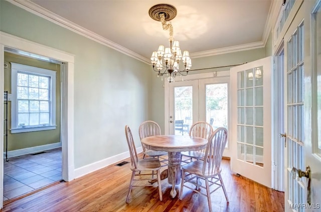 dining room featuring crown molding, a wealth of natural light, a notable chandelier, and french doors