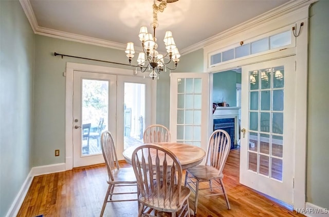 dining space with ornamental molding, light hardwood / wood-style flooring, and a notable chandelier