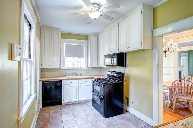 kitchen with sink, tasteful backsplash, black appliances, white cabinets, and ceiling fan with notable chandelier