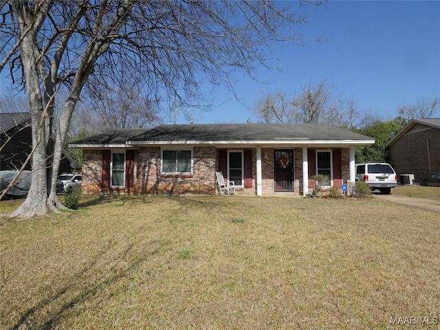 ranch-style home featuring covered porch and a front yard