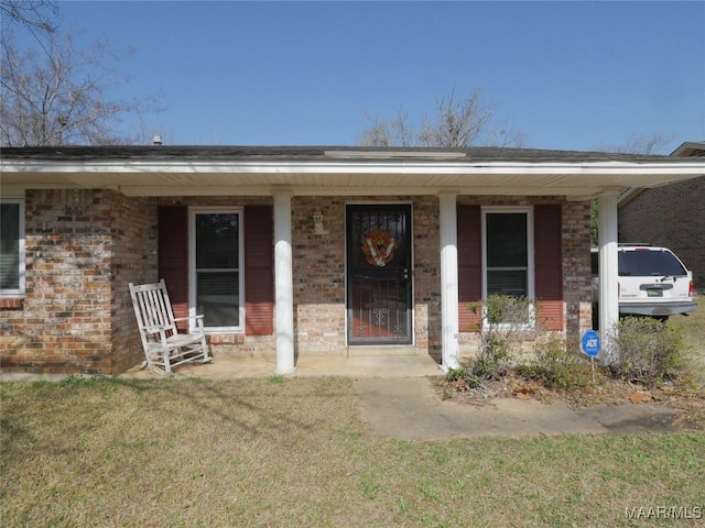 doorway to property with a yard and covered porch