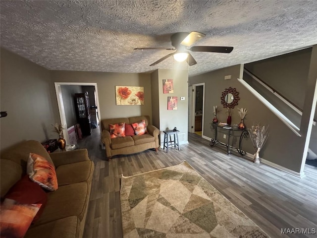 living room featuring ceiling fan, wood-type flooring, and a textured ceiling