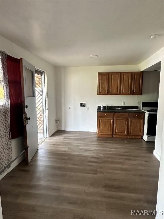 kitchen with dark countertops, dark wood finished floors, and white gas range