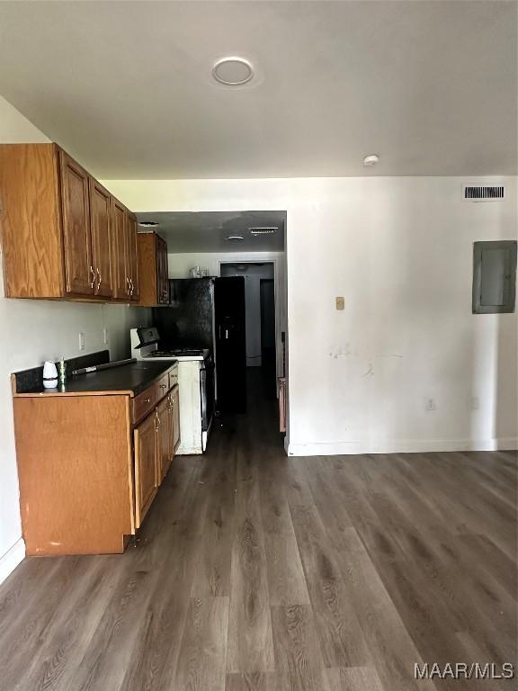 kitchen with dark wood-type flooring, electric panel, and range with gas cooktop