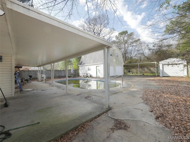 view of patio / terrace with a storage unit and a fenced in pool